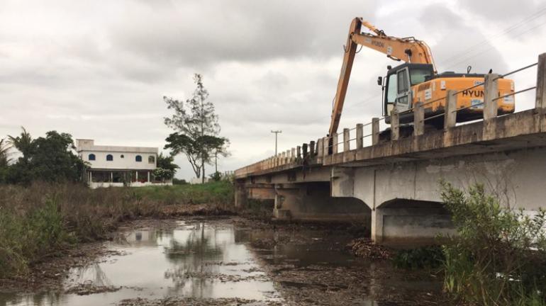 Três caminhões reforçam limpeza dos pilares da Ponte do Gote, em Campos